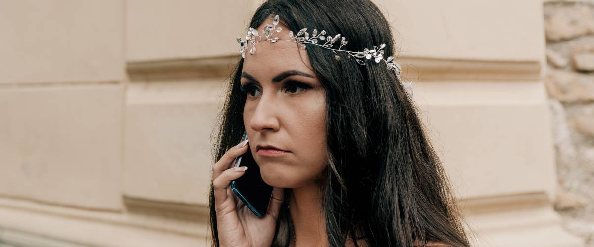 Portrait of beautiful bride talking on mobile phone on wedding day.