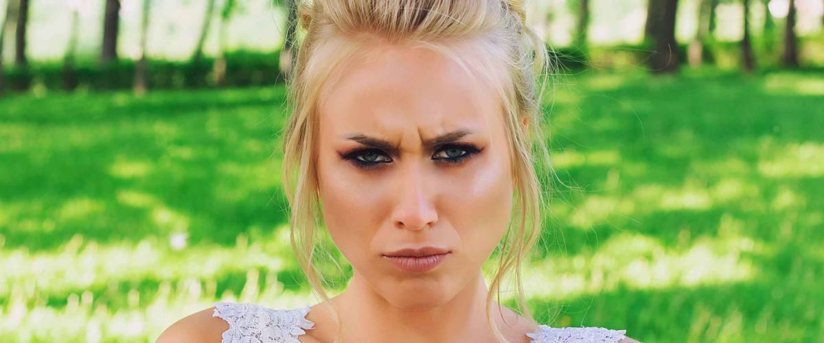 Offended and angry bride frowns looking at camera. Emotional model.