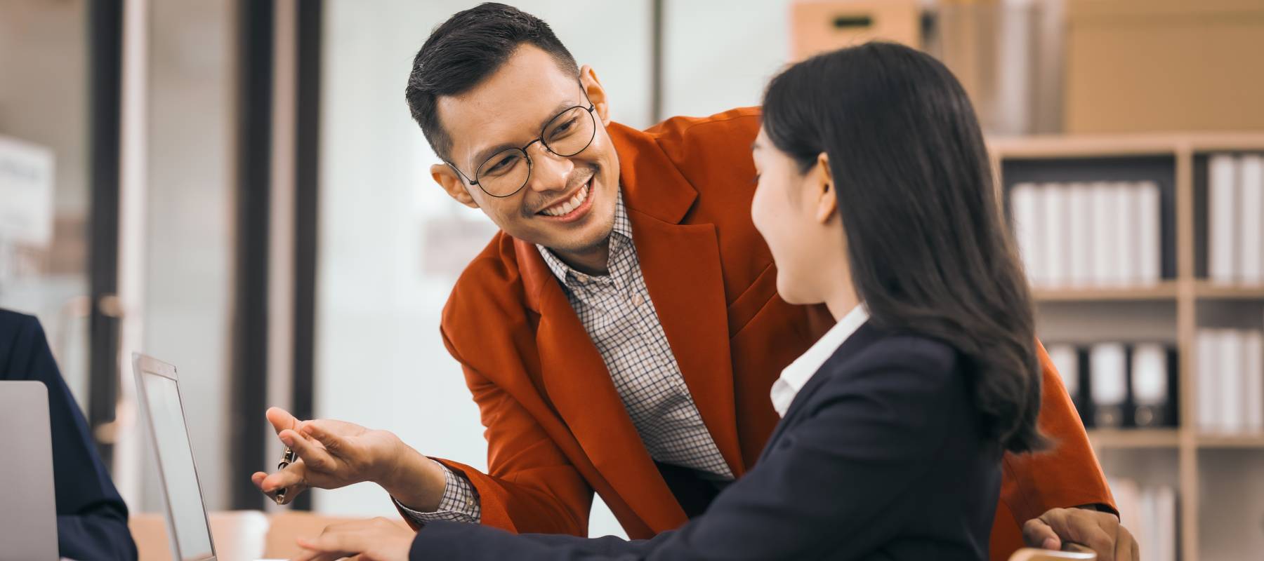 Two workers help one another with a task.