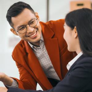 Two workers help one another with a task.