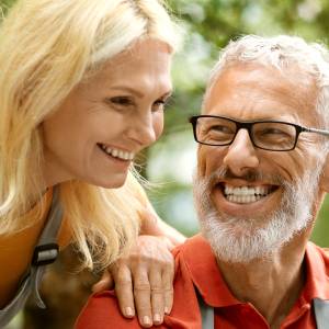 A happy older couple using a laptop outdoors.