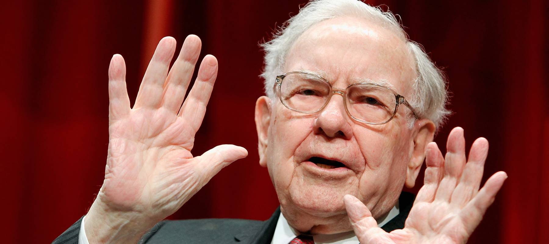 Warren Buffett holds up his hands as if to forestall questions.