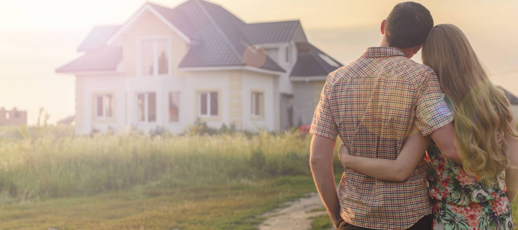 rear view of young couple looking at their new house
