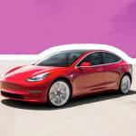 Toronto, Ontario / Canada September 20th 2019 : Photograph of a red Tesla model 3 in front of a distant city.