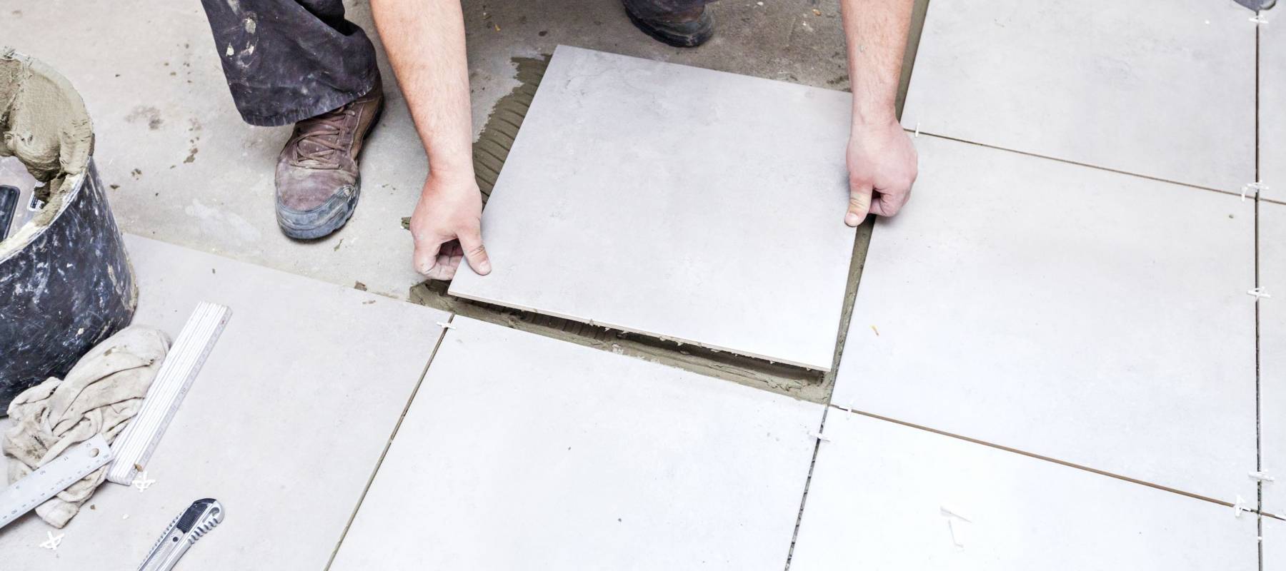 Tiling Floor &amp; Wall. The tiler builder arranges the bathroom ceramics.
