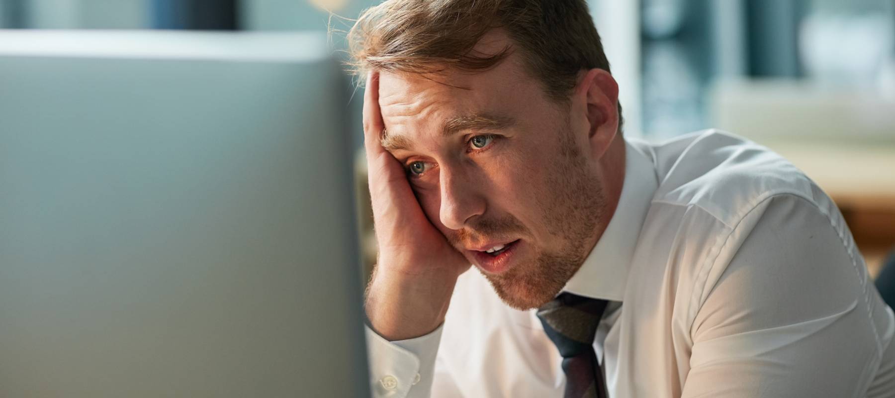 Tired employee staring at a computer screen.
