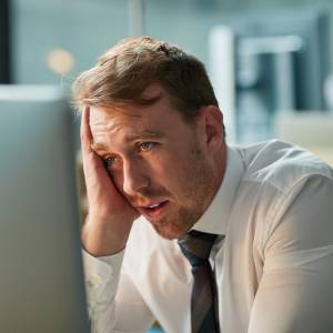 Tired employee staring at a computer screen.