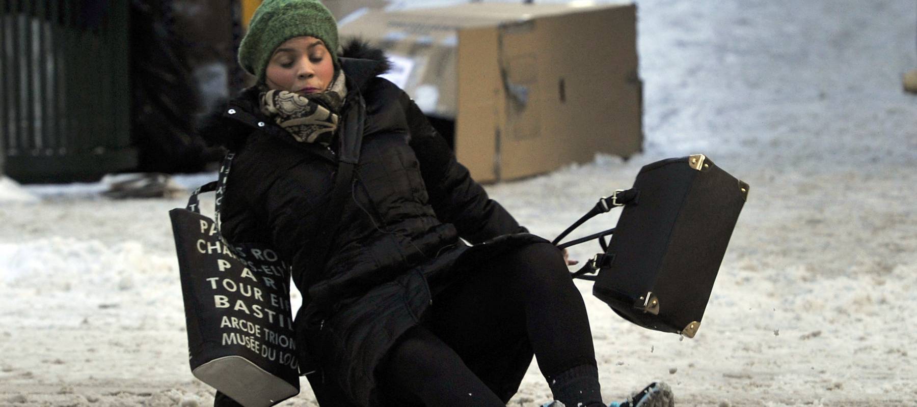 A woman falls on the ice and snow along 5th Ave. in New York City, Jan. 22, 2014.i