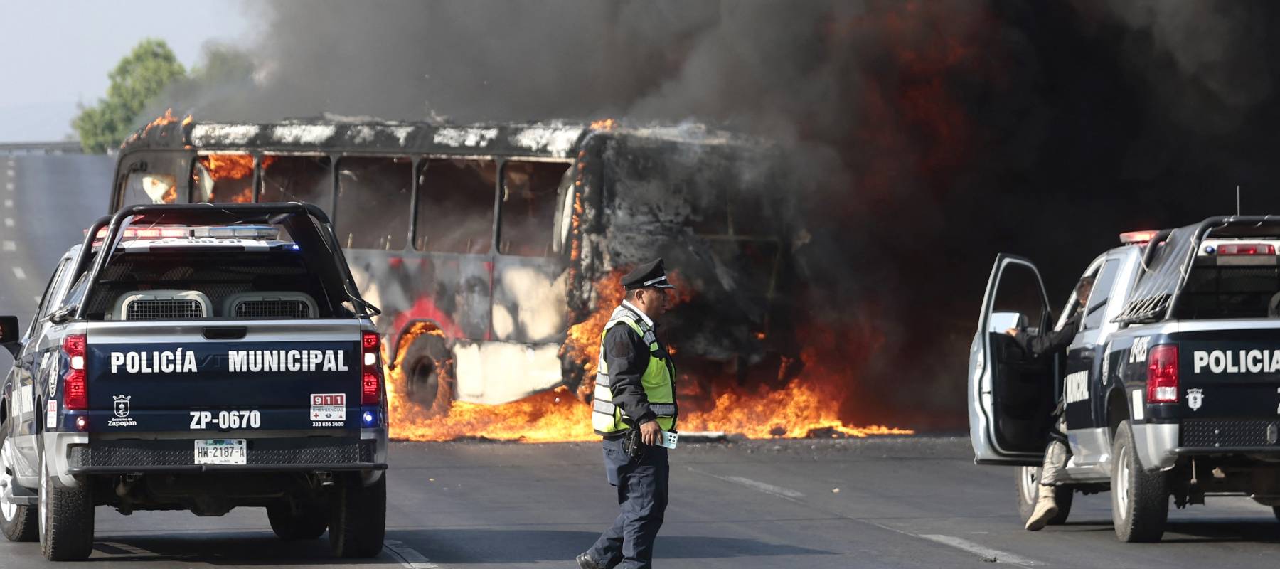 Police seen in front of a bus on fire in Jalisco, Mexico, on February 22, 2026..