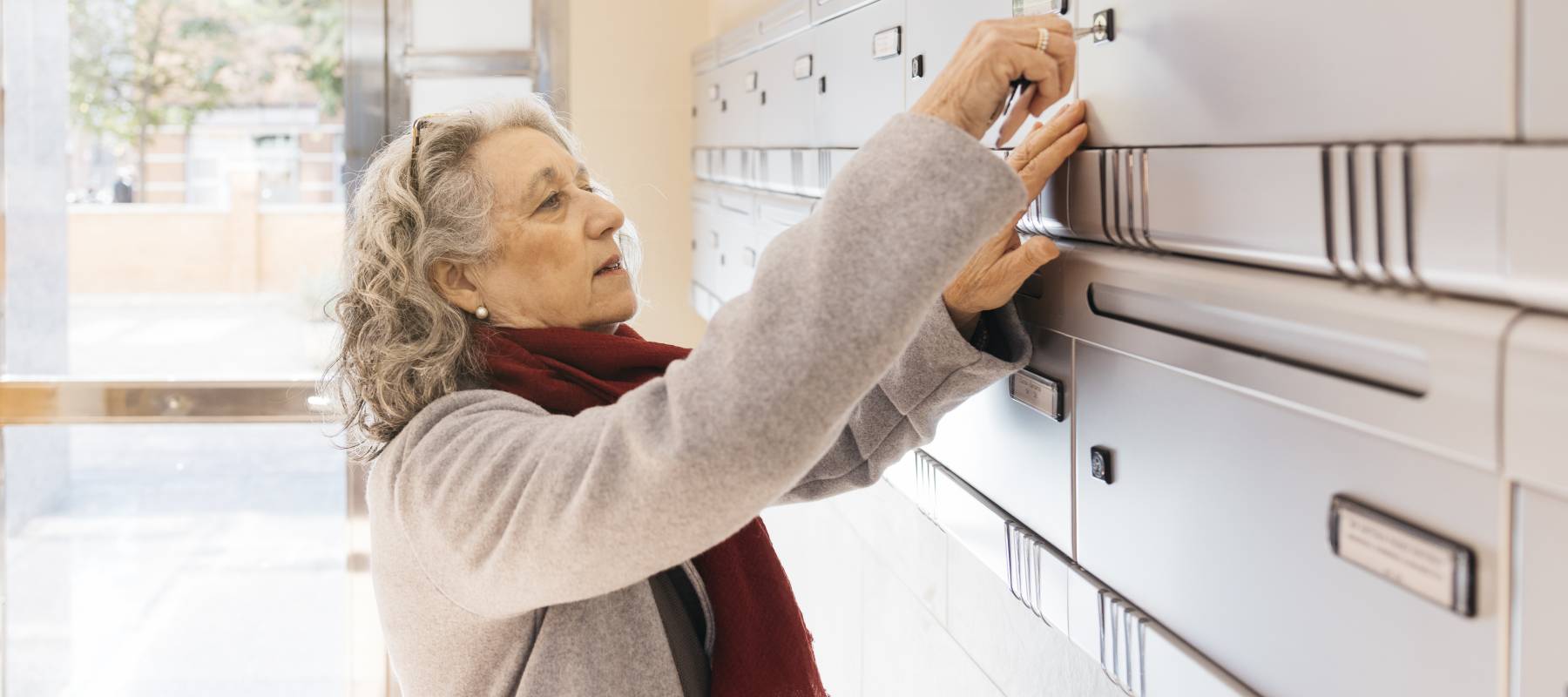 A woman checks the mailbox, like many people waiting on final tax refunds after a loved one dies.
