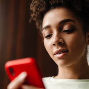 A woman checking her smartphone as cash-advance apps make  it increasingly easier for users to borrow against their paychecks.