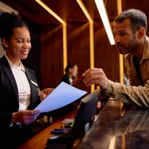 A man points to a bill at a hotel, one place where people are paying extra 'resort' and other fees.