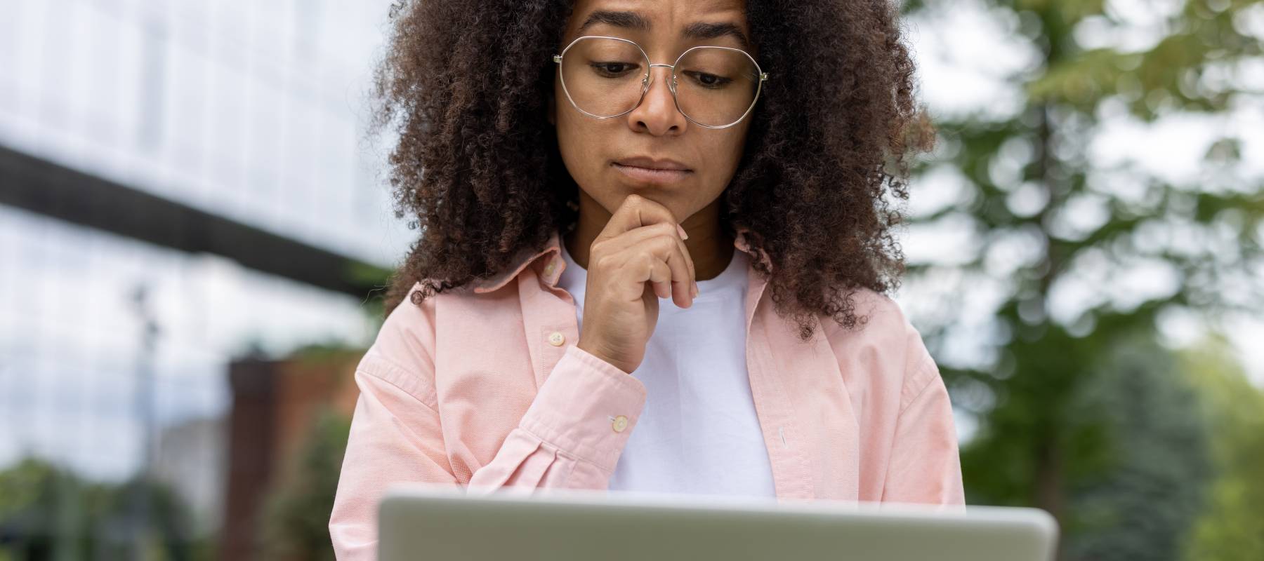 A woman looking at her laptop worries checks her credit report, one way people can monitor suspicious activity related to identity theft.