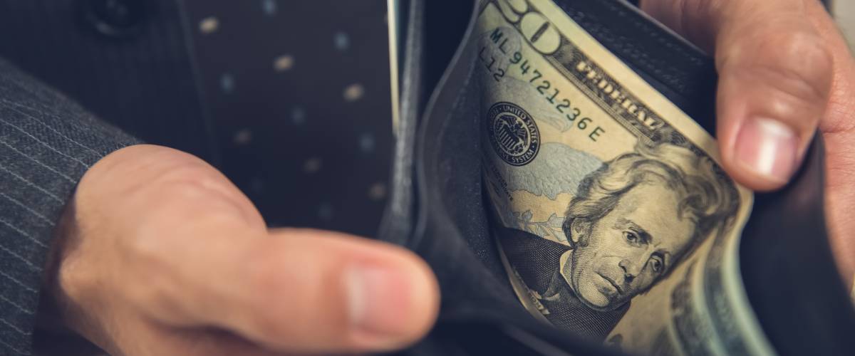 Person opening up their wallet and showing bills