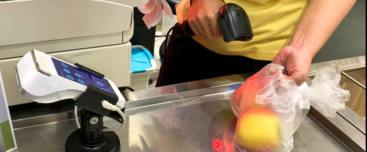Cashier scanning fruit at checkout