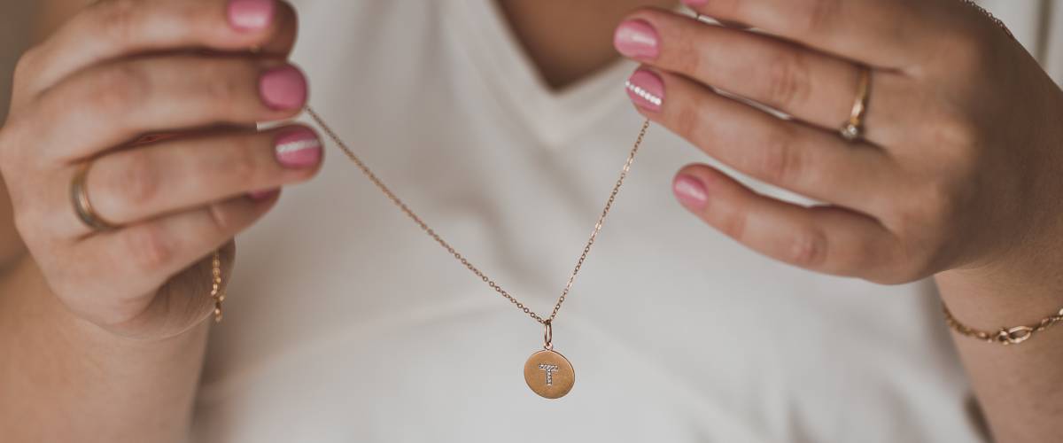 Person holding chain necklace with pendant