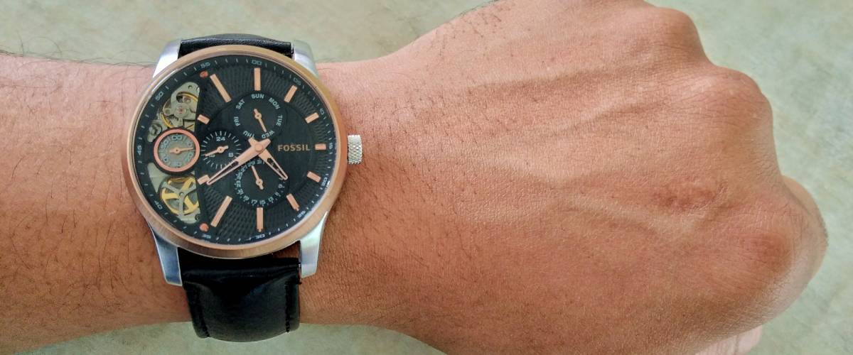 Man's wrist wearing black analog watch