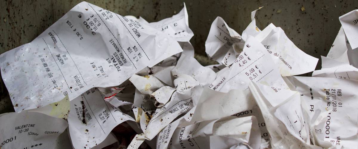Crumpled receipts in trash can