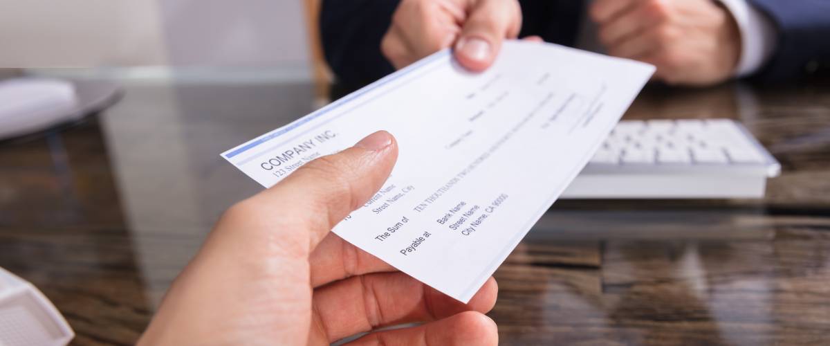 Person handing over a check to another person