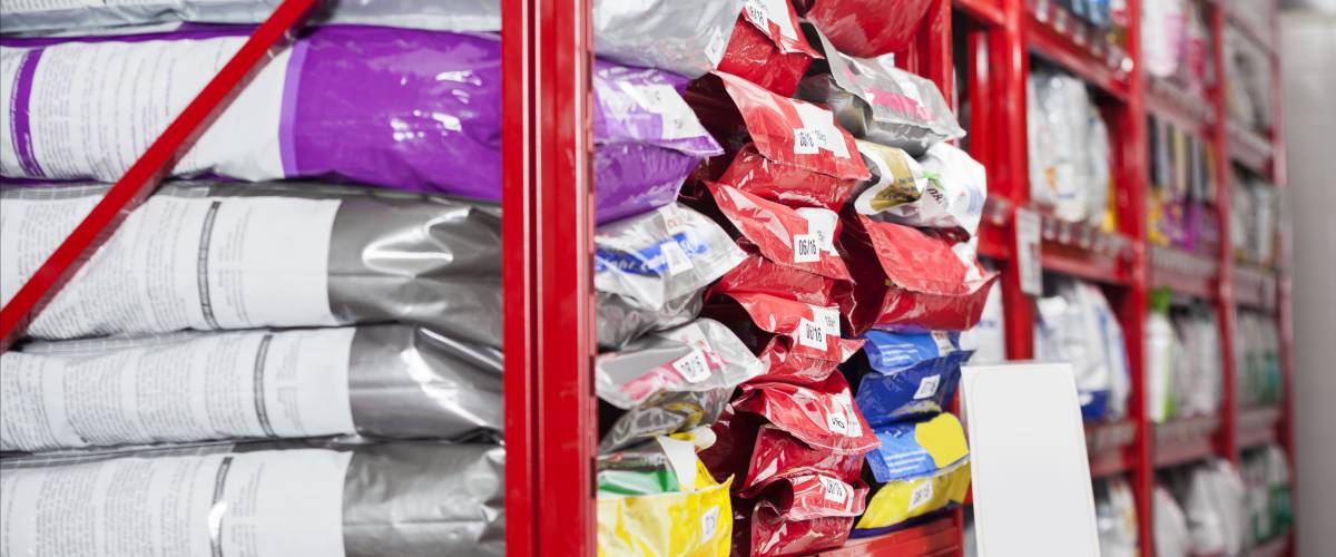 Bags of dog food stacked on a shelf