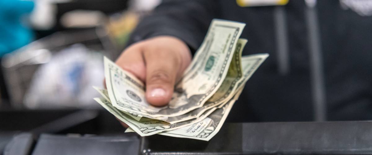 Cashier's hand giving back change.