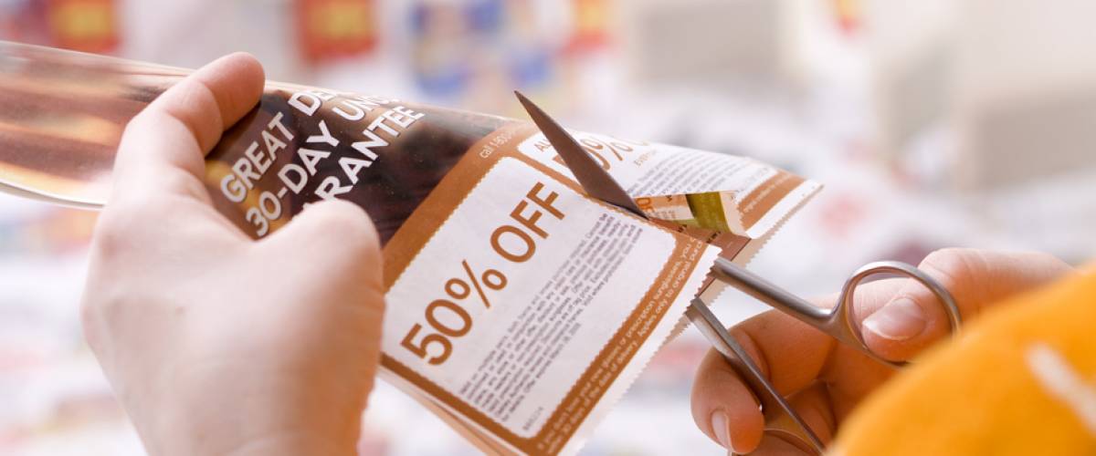 Woman cutting out paper coupon
