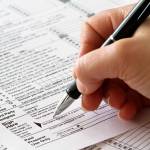 tax form with hand and pen