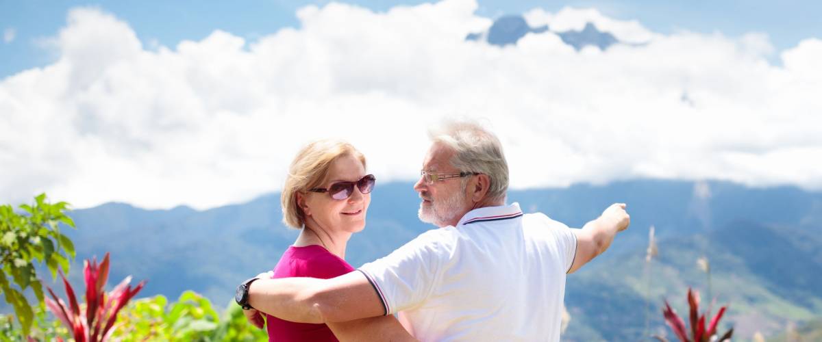 Senior couple hiking in mountains. Mature man and woman trekking in Borneo jungle. Family looking at Mount Kinabalu peak, highest mountain of Malaysia. Summer vacation in Southeast Asia.