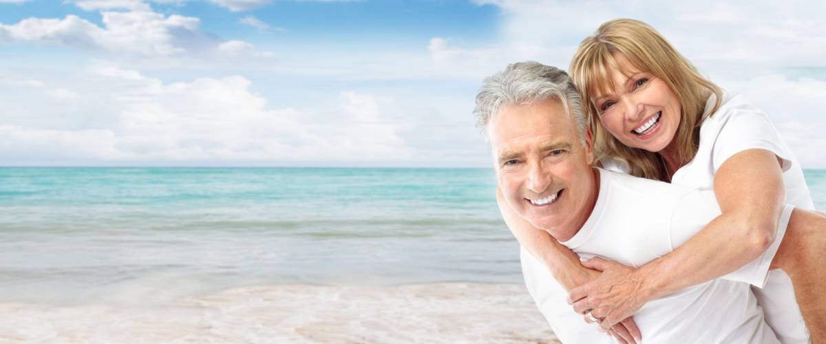 Happy senior couple on the beach. Exotic luxury resort.