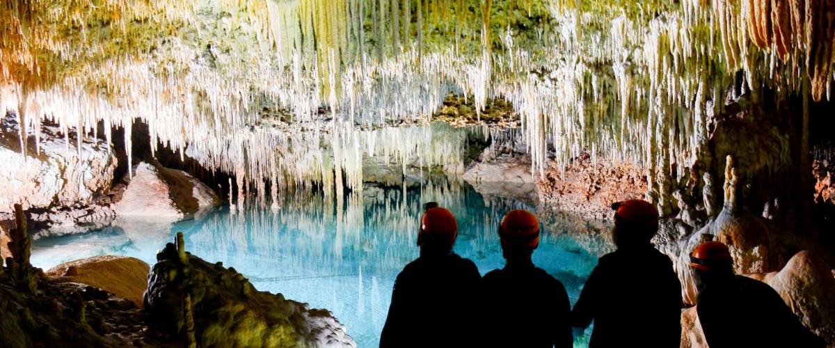 Silhouettes of four friends looking at the lake in the cave