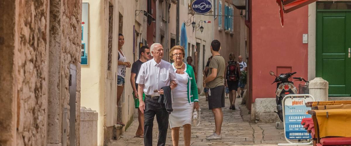 ROVINJ, ISTRIA PENINSULA, CROATIA - may 2018: cityscape. elderly couple walking charming narrow stone street in historical center of Rovinj, Croatia