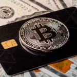 Silver bitcoin with credit card on top of dollars banknote background, new currency, accepting bitcoin for payment. Buy bitcoins online using credit or debit card concept.