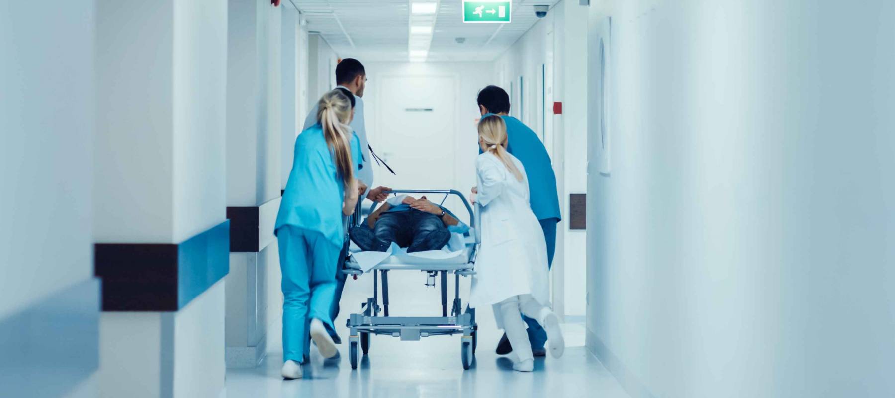 Doctors, Nurses and Paramedics Push Gurney with Seriously Injured Patient towards the Operating Room.