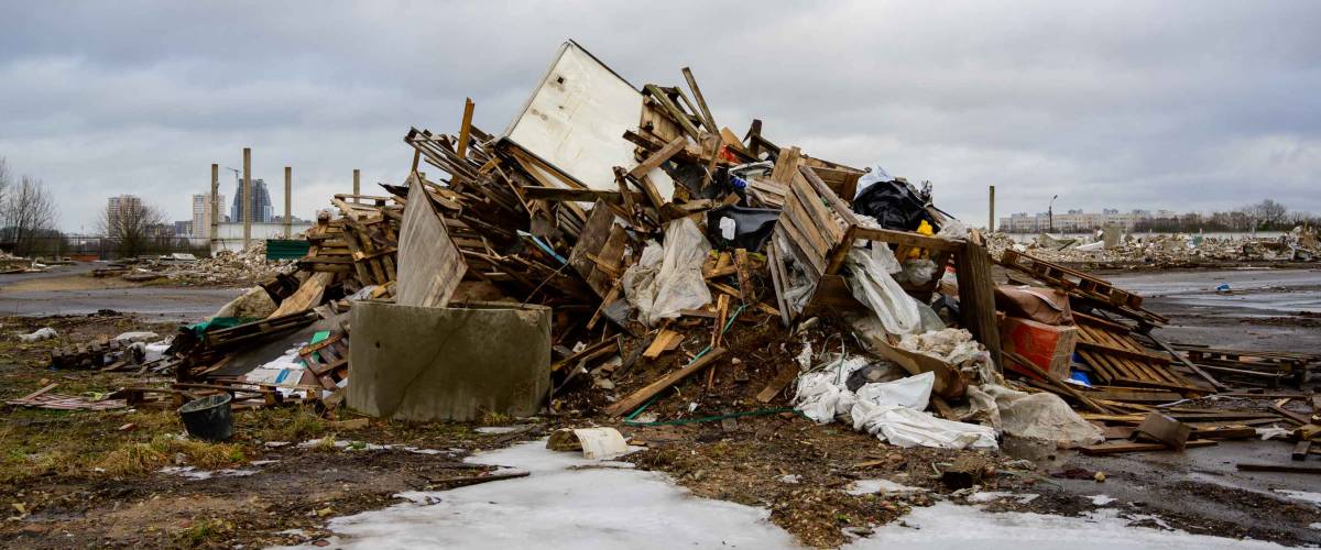 The concept of trash environmental disaster. Photo of a landfill on a street in a city on a cloudy day.