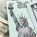 Macro view of the Statue of Liberty on a United States Treasury Check surrounded by currency.
