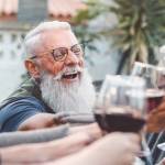 Happy family dining and toasting red wine glasses outdoor