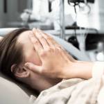Young woman patient lying at hospital bed feeling sad and depressed worried. Disease feeling sick in health care and clinical attention concept
