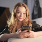 Smiling woman using her smartphone.