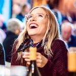 Happy friends having fun drinking white wine at street food festival
