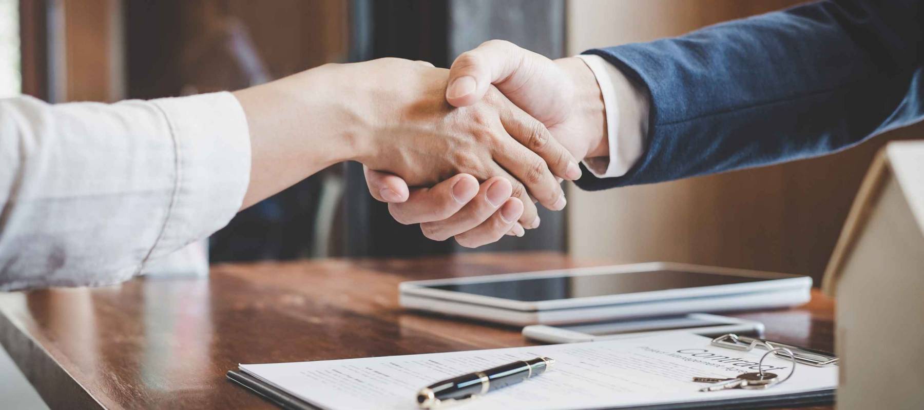 Real estate agent and customers shaking hands together celebrating finished contract after about home insurance and investment loan, handshake and successful deal.
