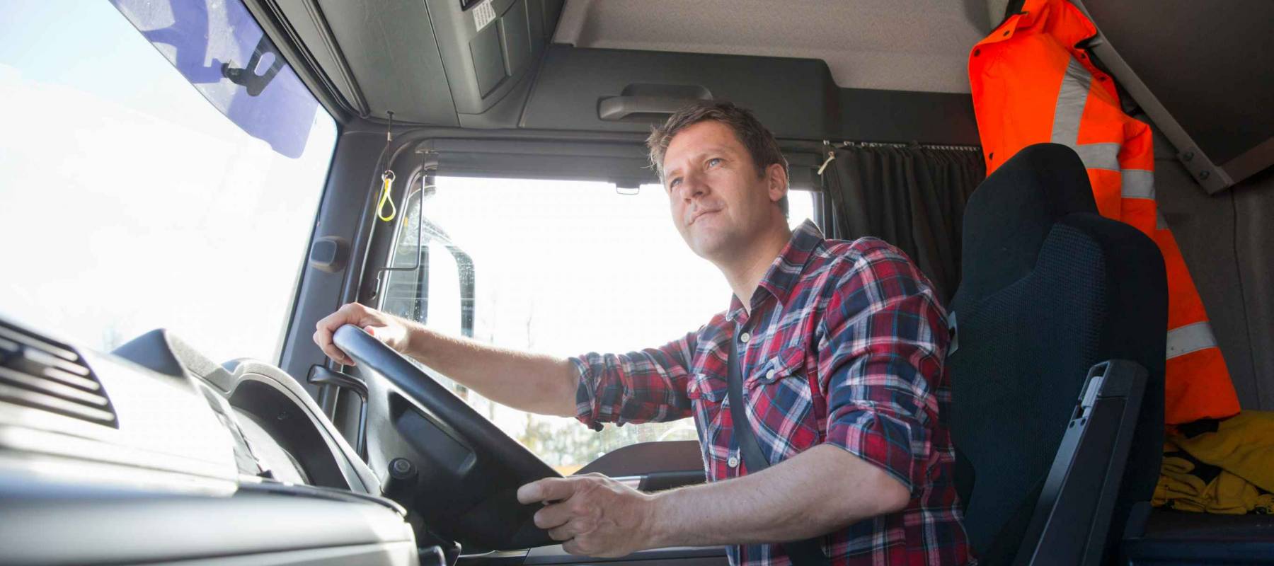 Truck driver driving in cab of semi-truck