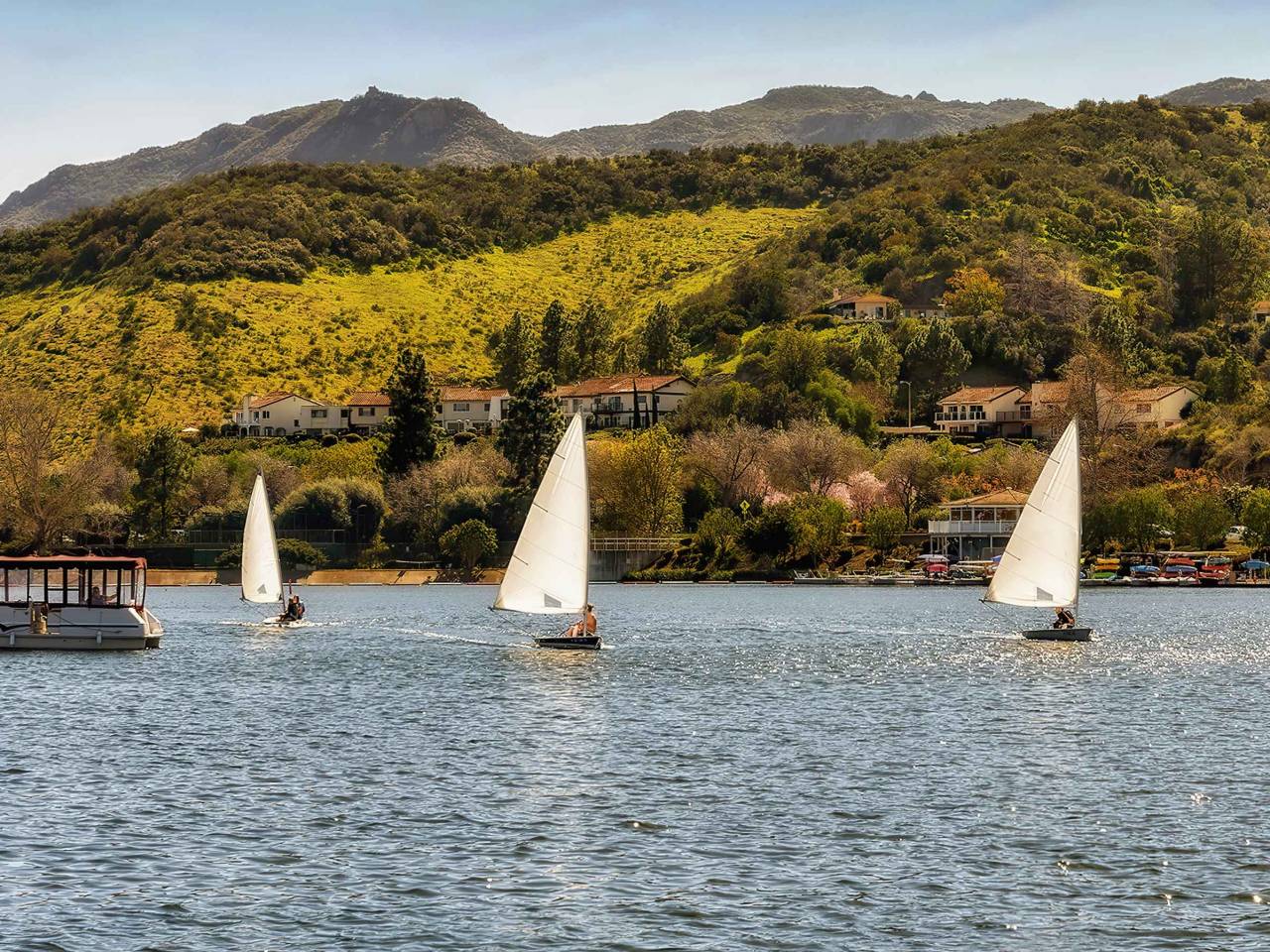 Sailboats sail in Westlake lake in Westlake Village, an upscale community in southern California.