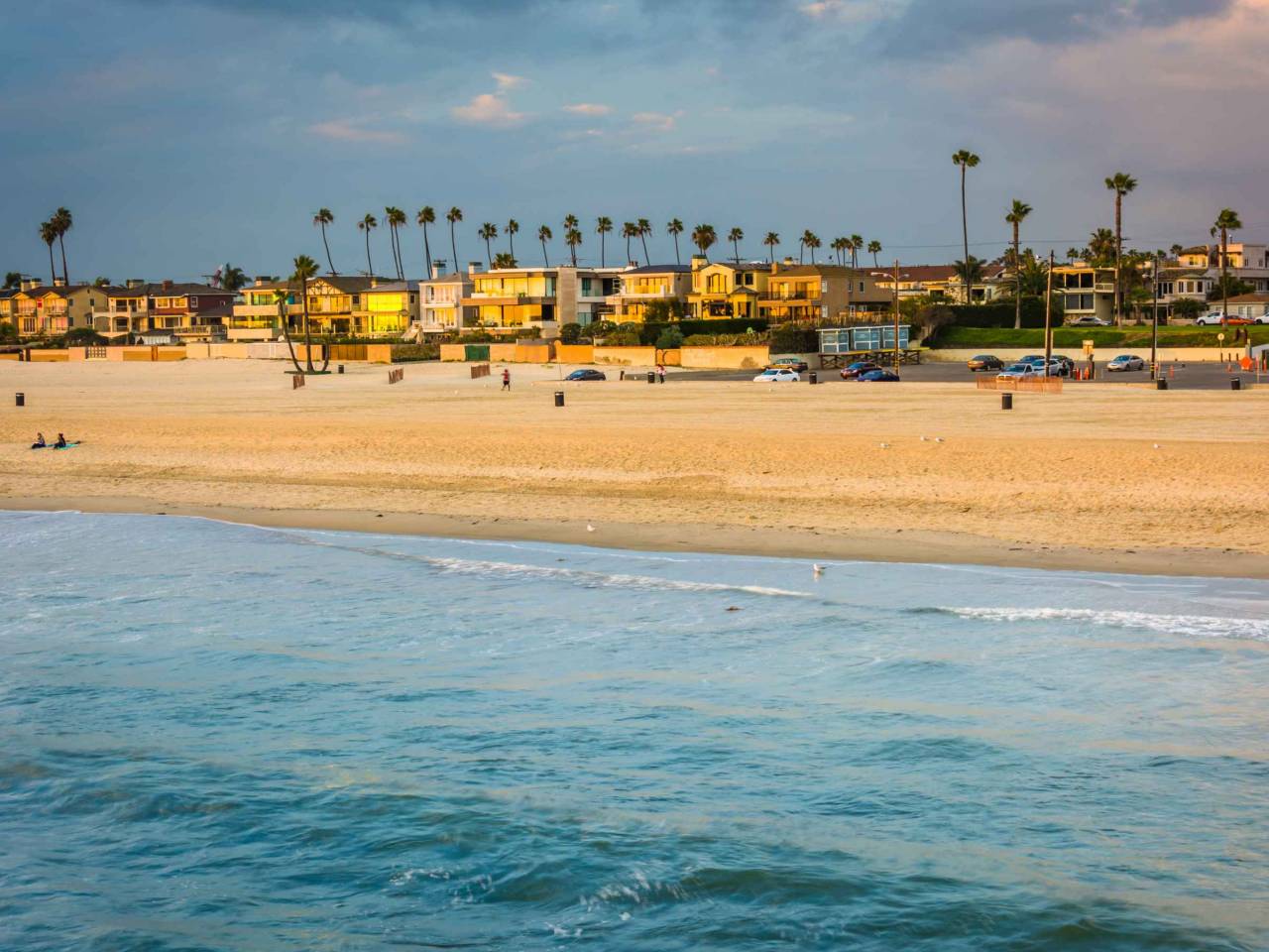 Waves in the Pacific Ocean and view of the beach at sunset in Seal Beach, California.