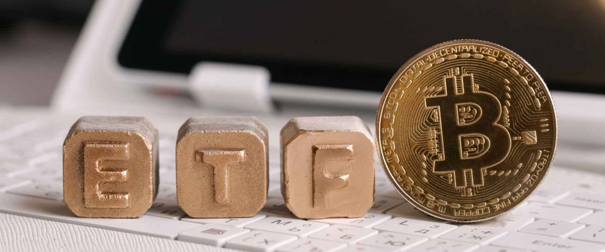 letters Gold ETF and Bitcoin on white keyboard