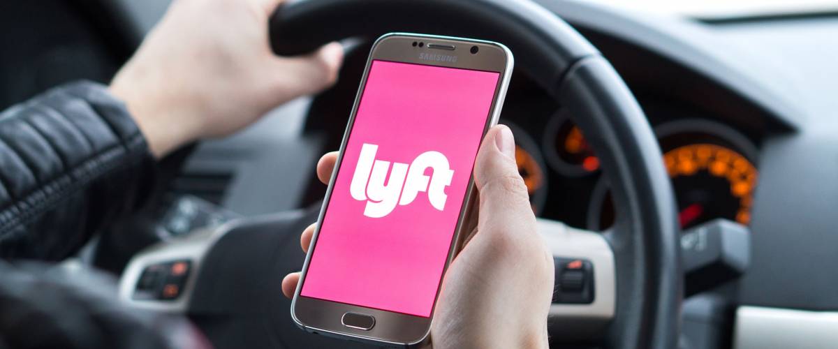 JYVASKYLA, FINLAND - DECEMBER 7, 2017: Lyft driver holding smartphone in car. Lyft is an American company offering transportation services online. Illustrative editorial.