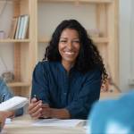 Happy african american businesswoman telling employees about work benefits