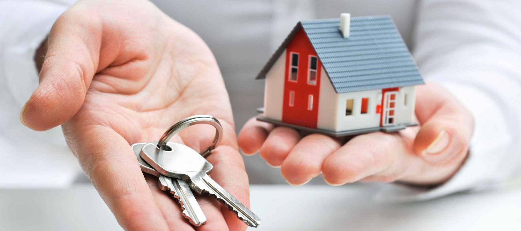 Real estate agent with house model and keys