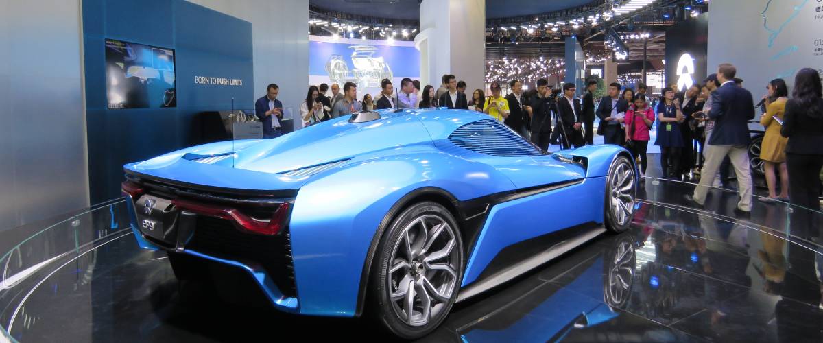 NIO vehicle, rear view, at a car show amid crowd of people