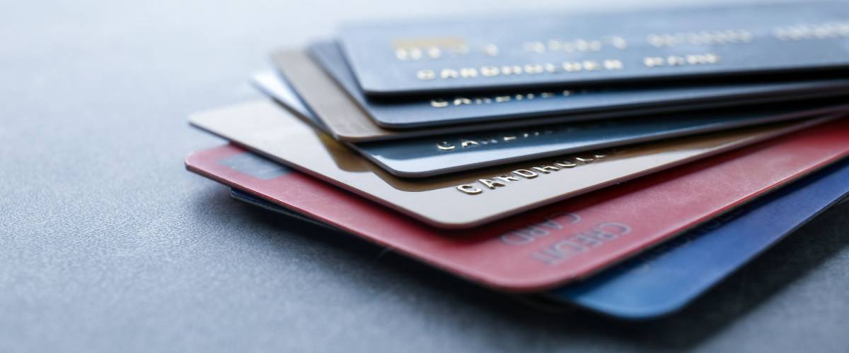 How A Money Expert Beat His Embarrassing Credit Card Debt - pile of credit cards on table closeup