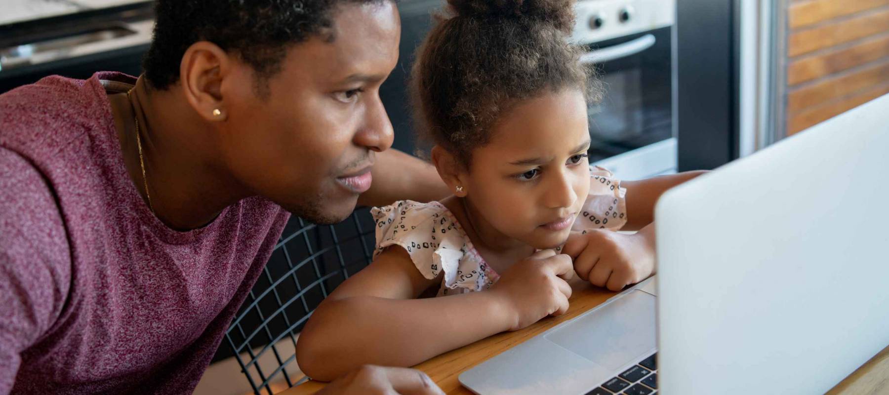 A father helping his daughter with homeschool.